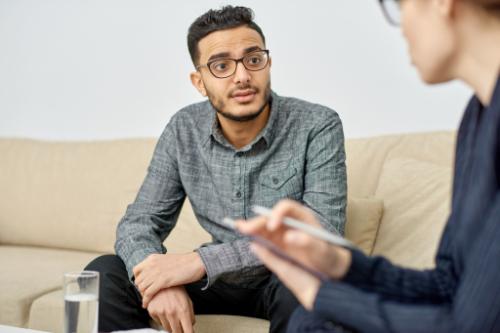 man in addiction evaluation with therapist
